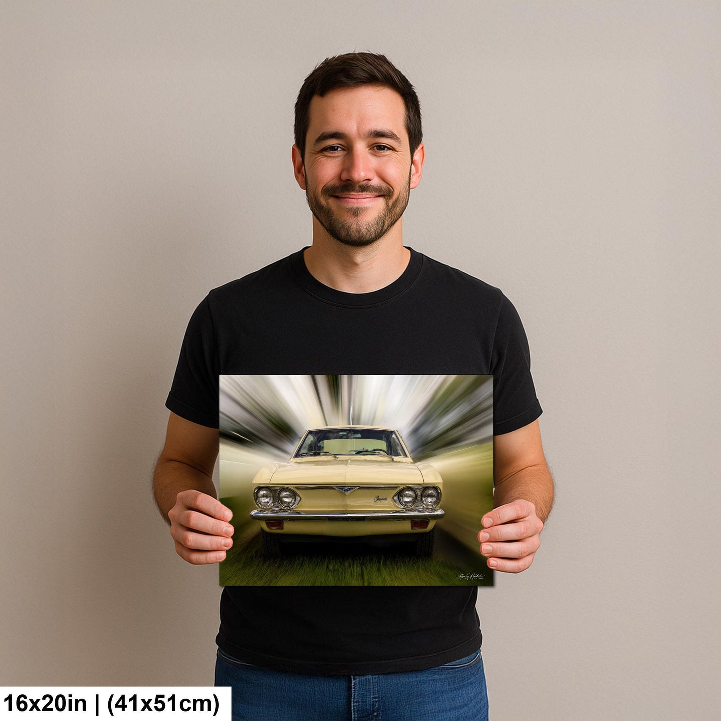 A man is holding a framed print of a yellow car in motion, with a blurred background.