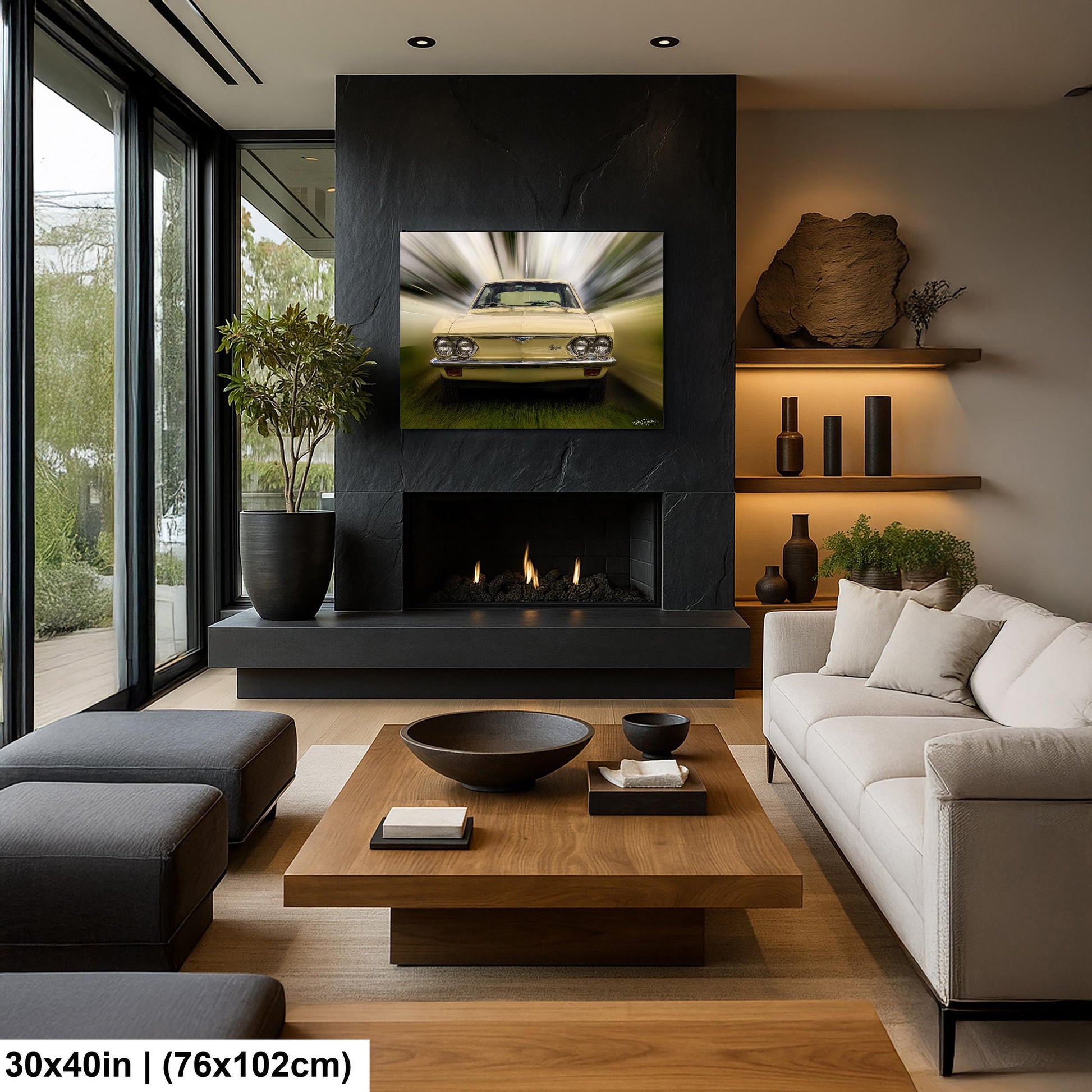 a modern living room with a large black fireplace, a wooden coffee table, a white sofa, and a large window overlooking a garden. A framed image of a car is displayed on the fireplace mantel, and the room is decorated with various vases, books, and other decorative items.