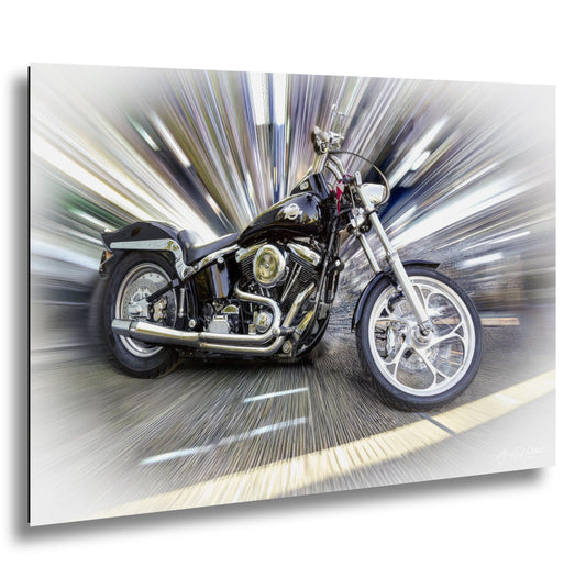 A black and chrome Harley Davidson motorcycle is shown in motion, with a blurred background that creates a sense of speed and movement.