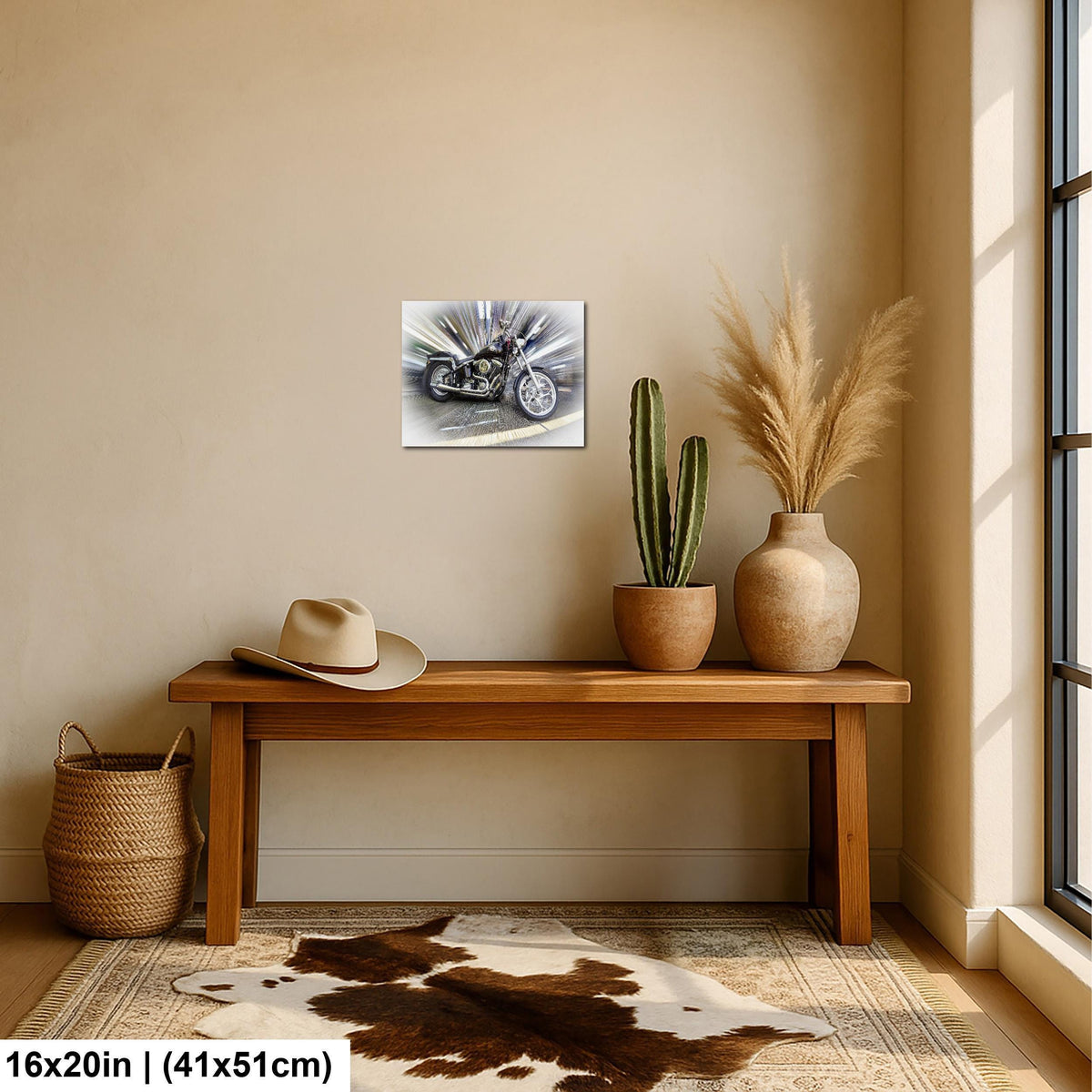 a wooden bench with a cowboy hat and a potted cactus plant on it, along with a framed poster of a motorcycle on the wall.